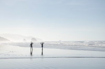 两名男子在水体附近携带冲浪板